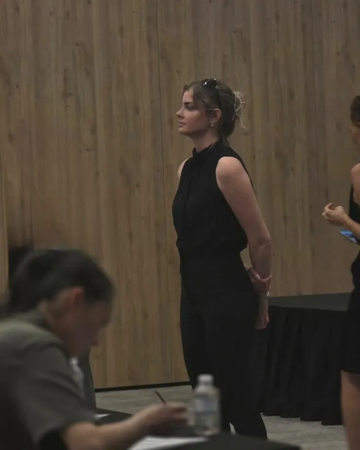 A Niz Eğitim invigilator watching the hall while a participant writes